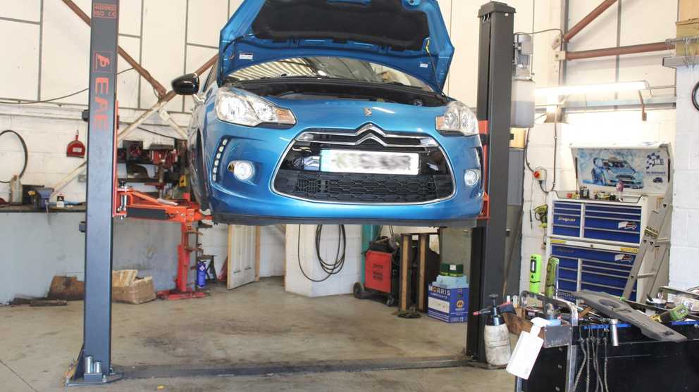 Car suspended in the air being serviced