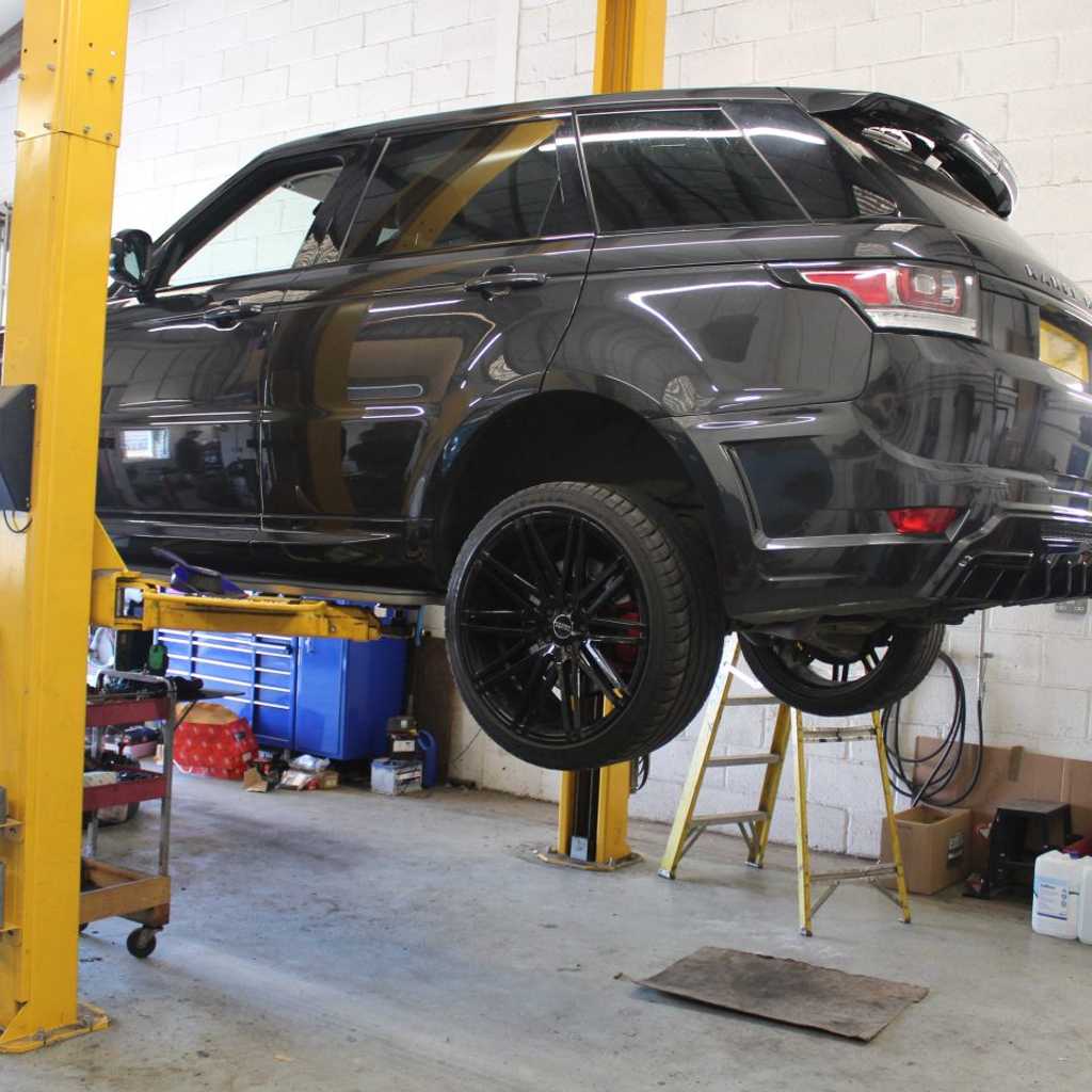 A car suspended in the air being readied for its MOT
