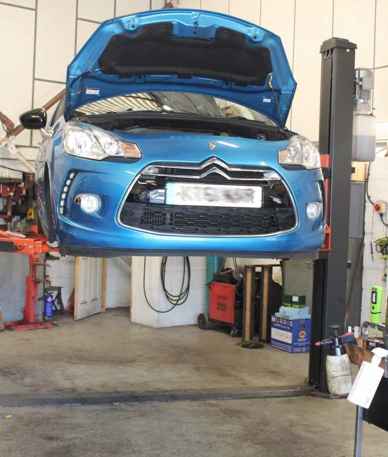 Car suspended in the air being serviced